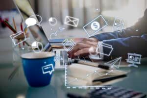 ilustração do ideal de négocio e marketing, com um notebook e um homem empresário digitando com imagens que remetem á junção de internet e empresário, aos redores.